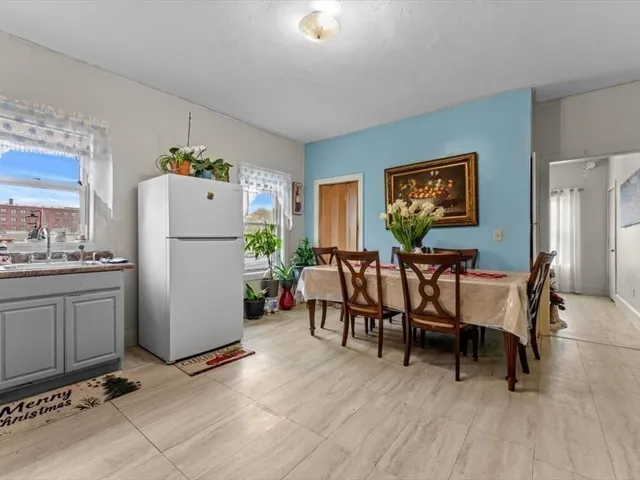 a dining room with furniture and a refrigerator