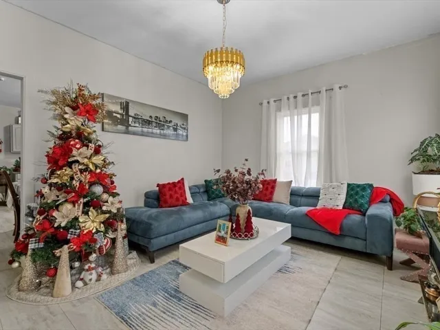 a living room with furniture and a chandelier