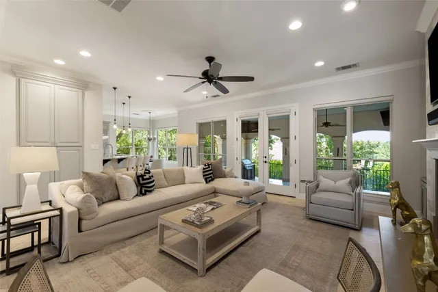 a living room with furniture a ceiling fan and a chandelier