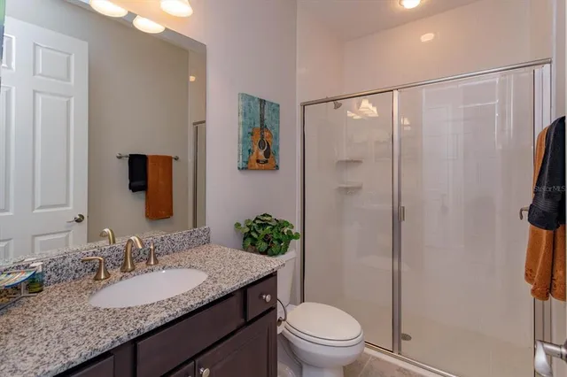a bathroom with a granite countertop sink toilet and shower