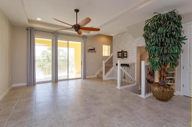a view of a livingroom with a large window wooden floor and a ceiling fan
