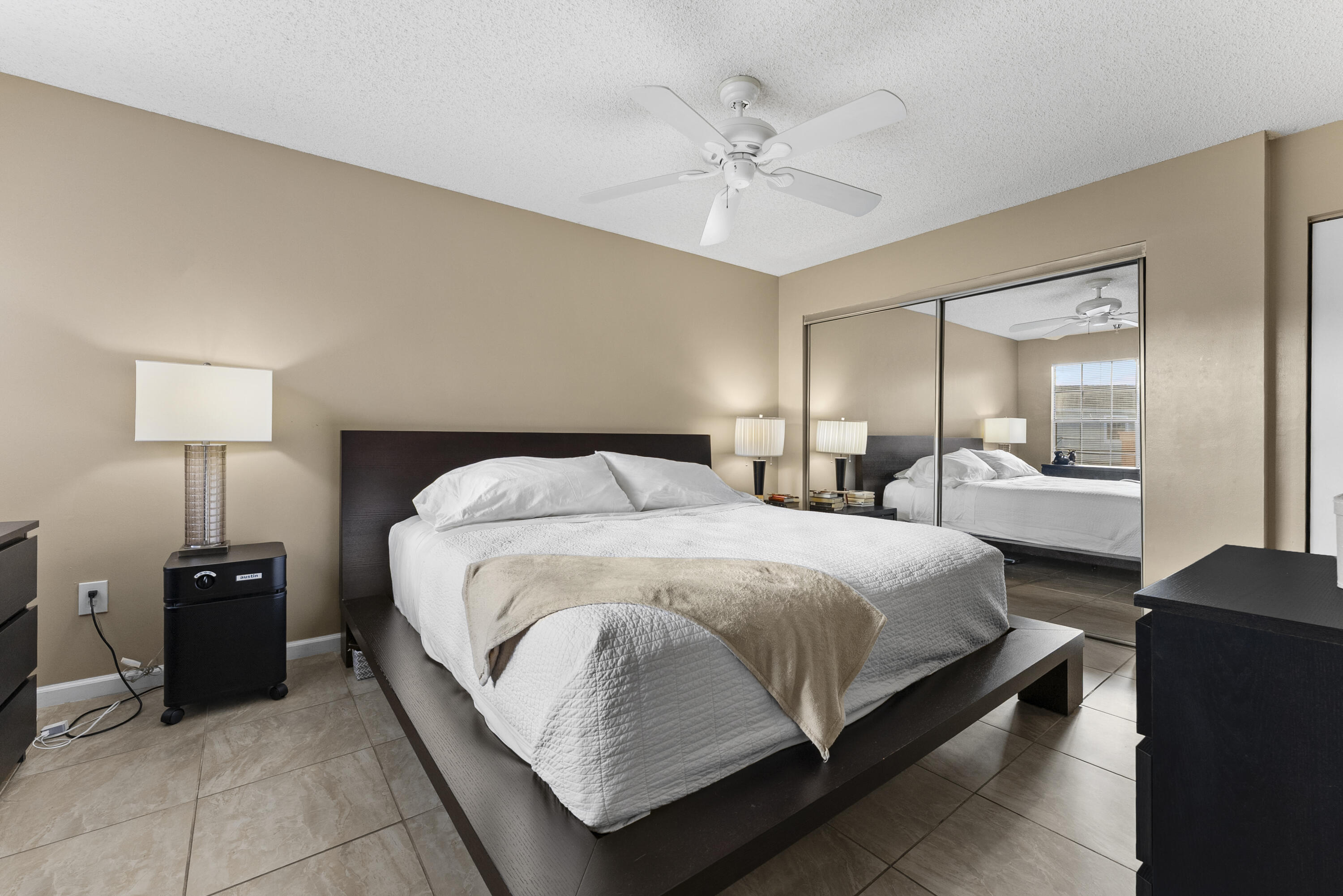 1365 Crystal Way, Unit H Delray Beach, FL 33444 - Photo 12 of 34 a spacious bedroom with a bed and lamp