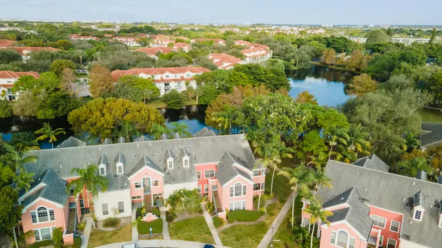 an aerial view of residential houses with outdoor space and trees