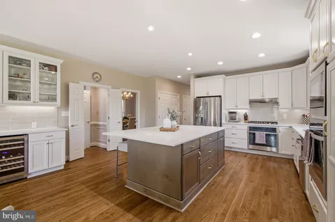a kitchen with stainless steel appliances kitchen island granite countertop a stove a sink a refrigerator and cabinets