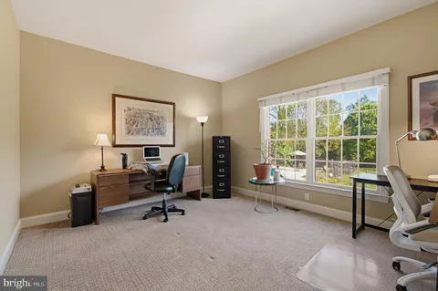 a view of a workspace with furniture and a window