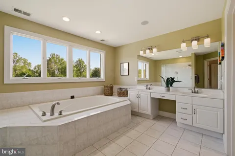 a spacious bathroom with a large tub sink and window