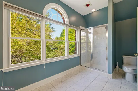 a bathroom with a toilet a sink and a large mirror