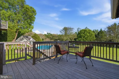 a view of a deck with wooden floor and fence with a bench