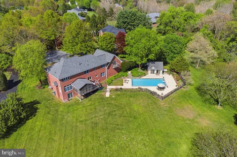 an aerial view of residential house with outdoor space and trees all around