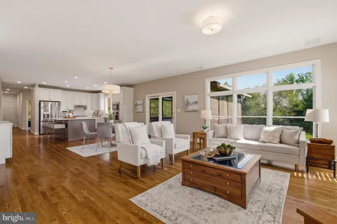 a living room with furniture wooden floor and a large window