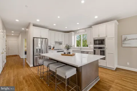 a large kitchen with kitchen island a sink table and chairs