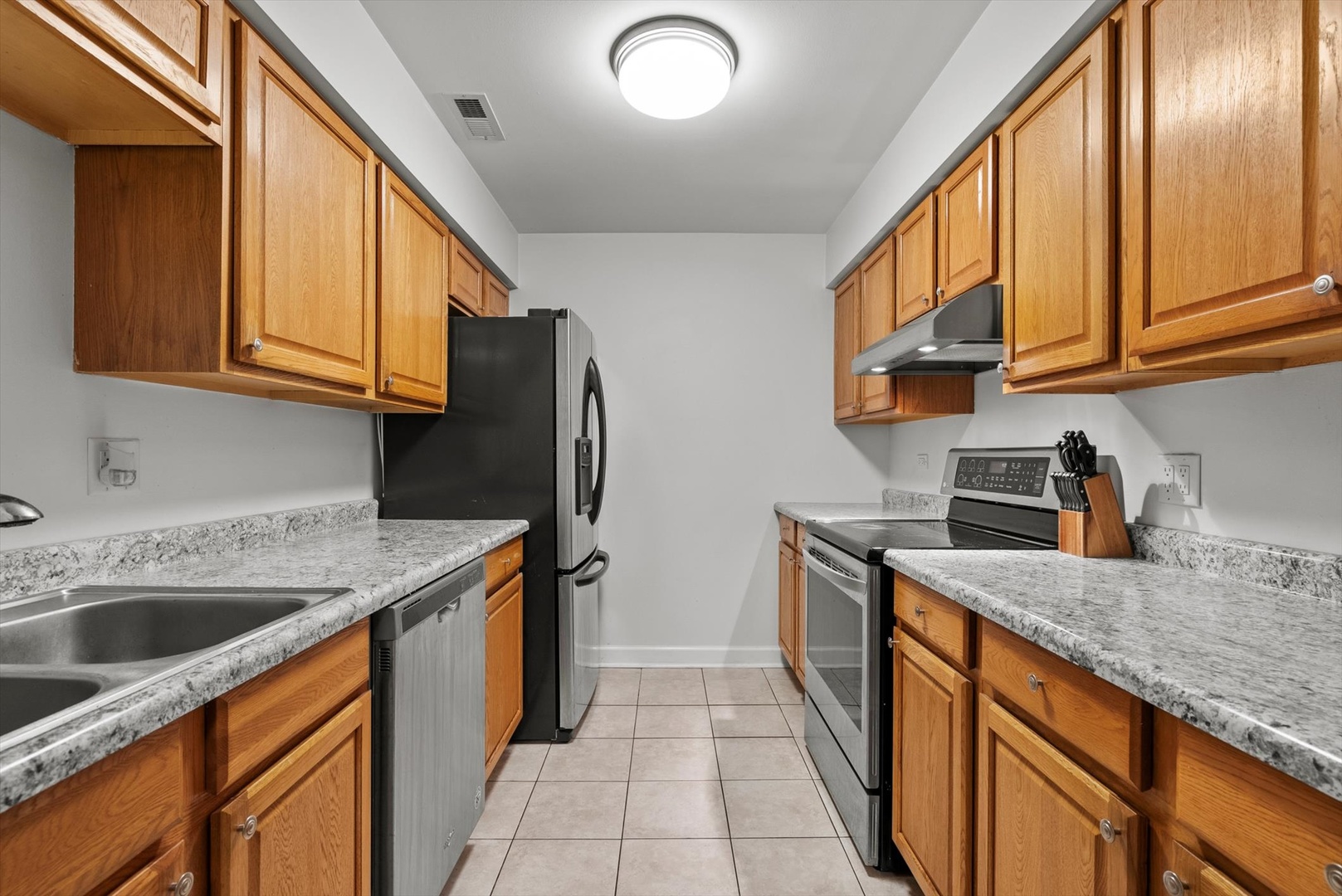 1426 Stonebridge Circle, Unit K8 Wheaton, IL 60189 - Photo 10 of 20 a kitchen with stainless steel appliances granite countertop a sink stove and refrigerator