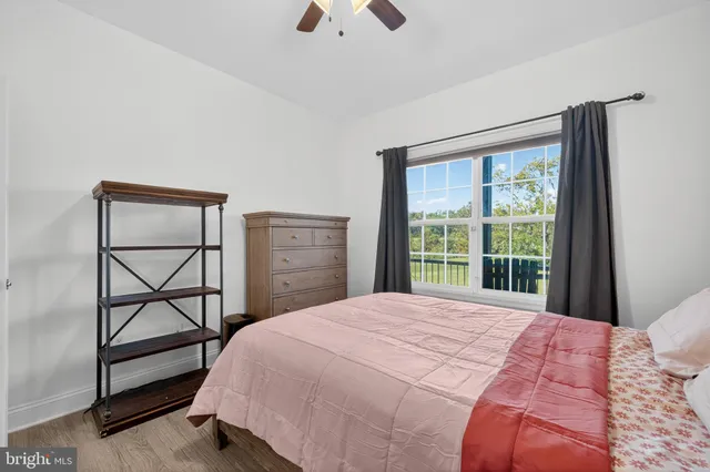 a bedroom with a bed a chandelier and a large window