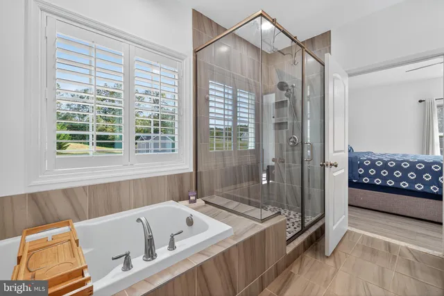 a bathroom with a tub a sink and glass door shower