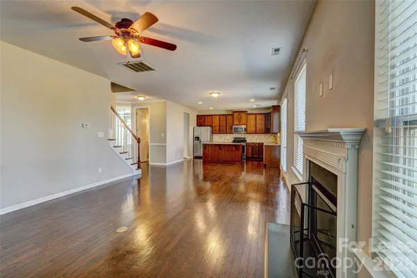 a view of a livingroom with furniture a ceiling fan and kitchen view