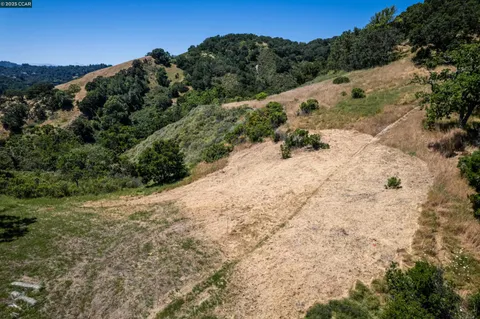 a view of a dry yard with mountains in the background