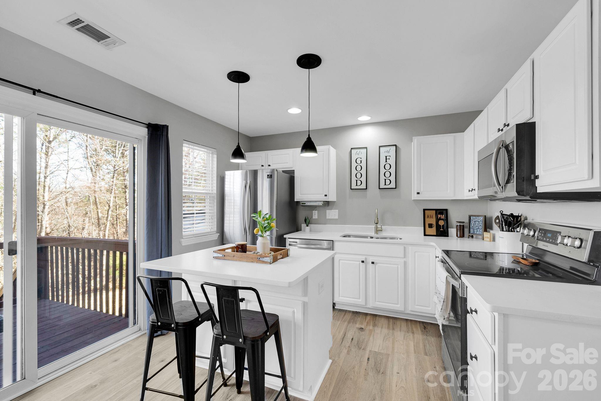 1570 Maypine Commons Way Rock Hill, SC 29732 - Photo 10 of 23 a kitchen with a dining table chairs wooden floor and appliances