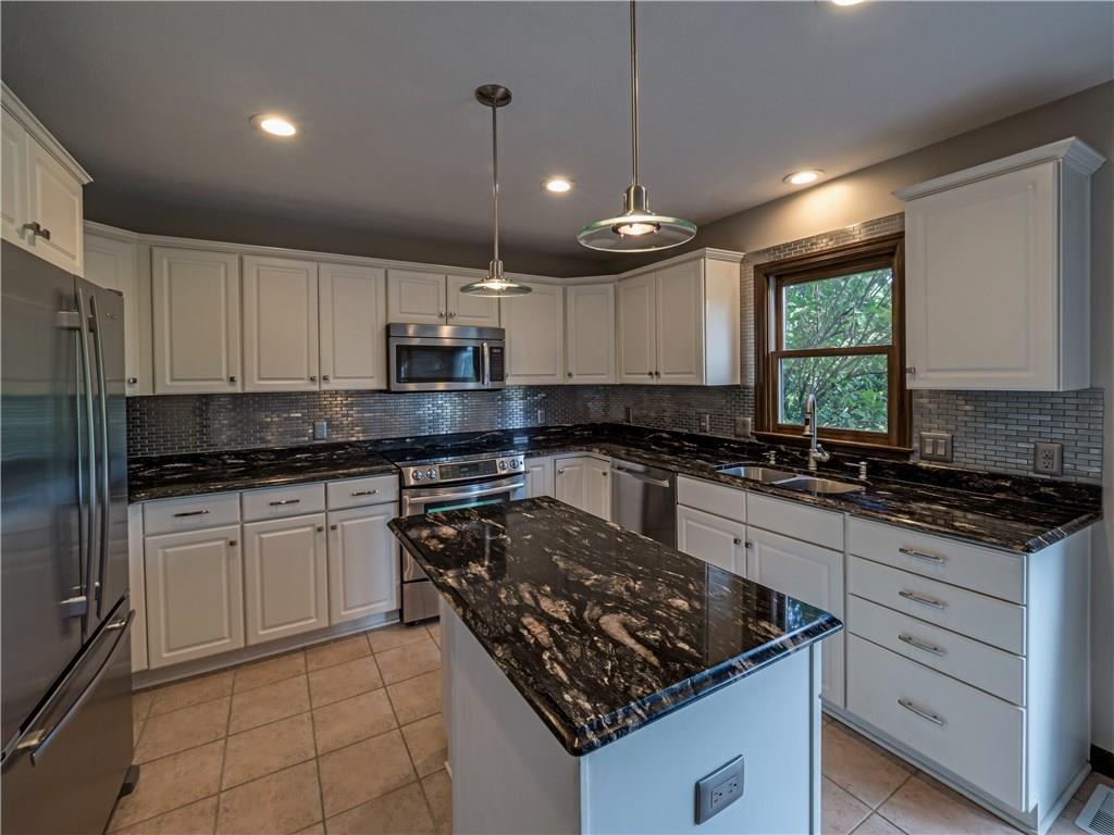 7003 Eagle Road Gibsonia, PA 15044 - Photo 7 of 25 The stunning updated kitchen boasts endless beautiful dark granite counter tops complimenting the immaculate white cabinetry.