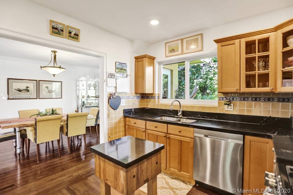 1301 South Biscayne Point Road Miami Beach, FL 33141 - Photo 12 of 45 a kitchen with stainless steel appliances granite countertop a stove a sink a dining table and chairs with wooden floor