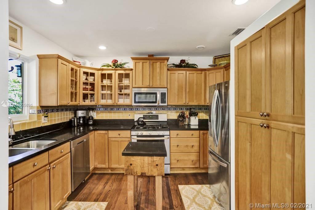 1301 South Biscayne Point Road Miami Beach, FL 33141 - Photo 13 of 45 a kitchen with stainless steel appliances a refrigerator a sink and wooden cabinets