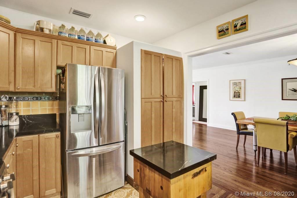 1301 South Biscayne Point Road Miami Beach, FL 33141 - Photo 14 of 45 a kitchen with stainless steel appliances granite countertop a refrigerator a stove and a dining table with wooden floor