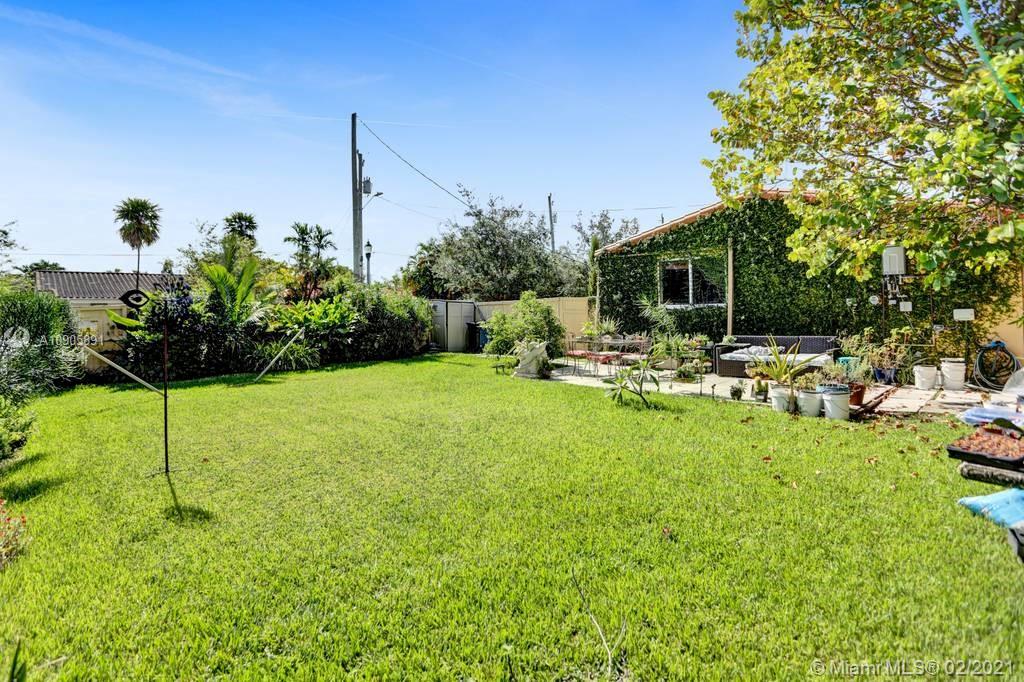 1301 South Biscayne Point Road Miami Beach, FL 33141 - Photo 25 of 45 a backyard of a house with table and chairs