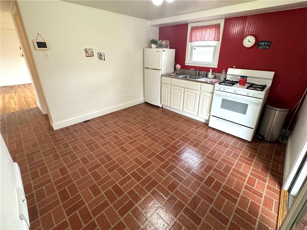 794 4th Street Rochester, PA 15074 - Photo 4 of 20 a kitchen with granite countertop a stove a sink and a refrigerator