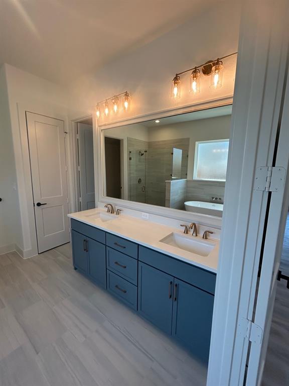 415 East Burks Street Pilot Point, TX 76258 - Photo 9 of 13 a bathroom with a double vanity sink and a mirror