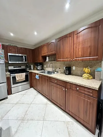 a kitchen with a sink a microwave and cabinets