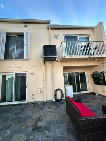 a roof deck with couches and potted plants