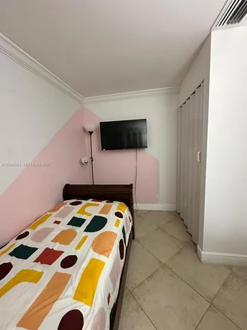 a bedroom with a bed and a tv