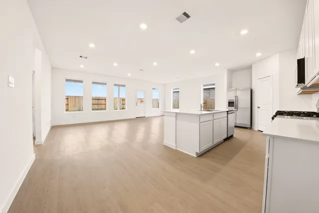 a kitchen with stainless steel appliances a stove a sink a microwave and cabinets