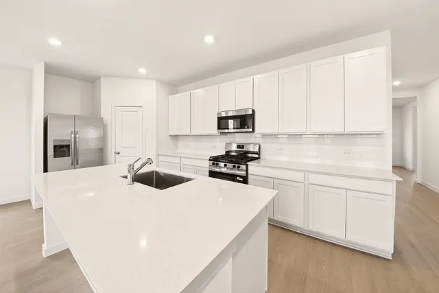a kitchen with white cabinets and stainless steel appliances