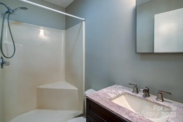 a bathroom with a granite countertop sink a toilet and a mirror