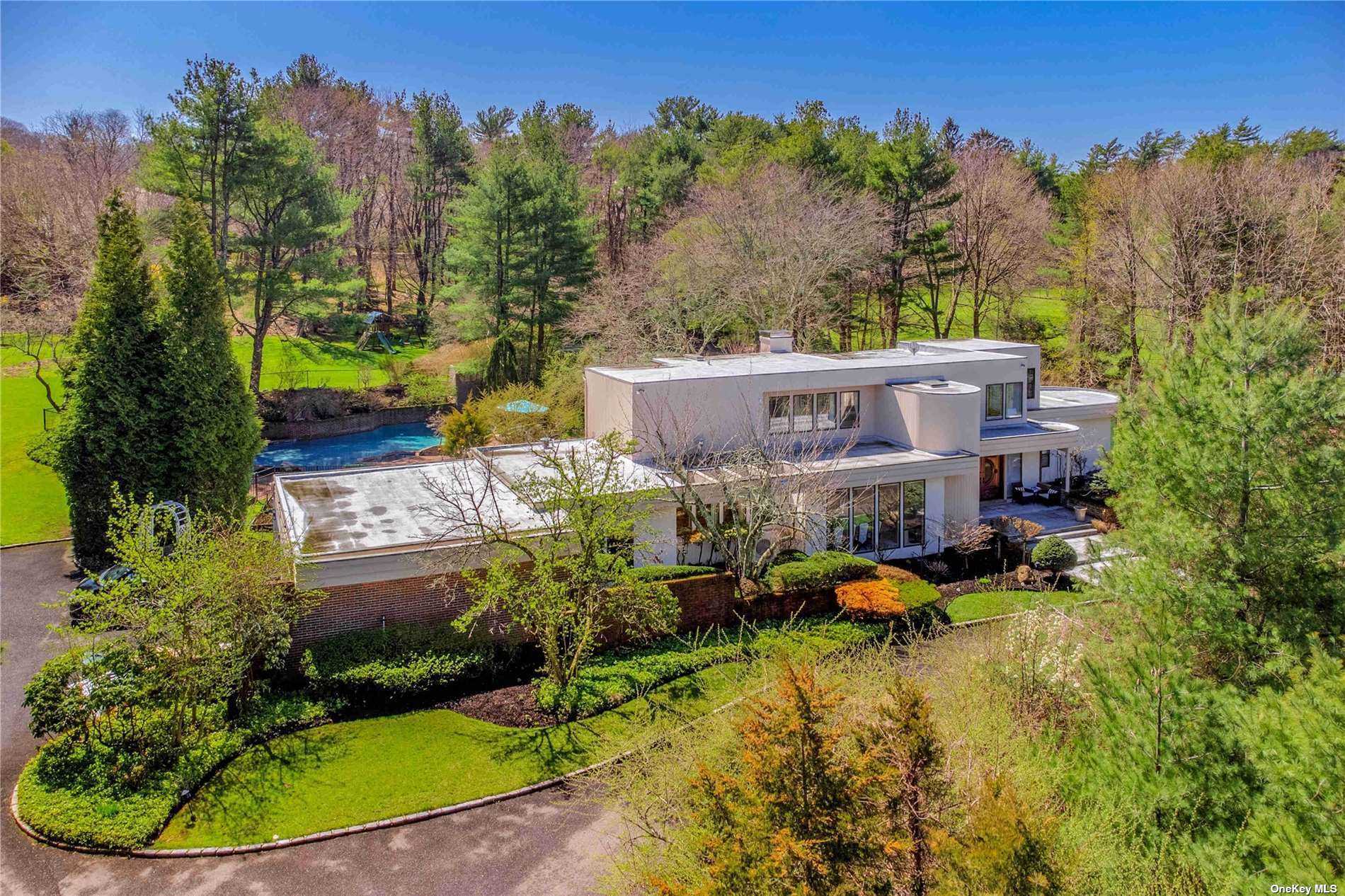 an aerial view of a house with a garden and lake view