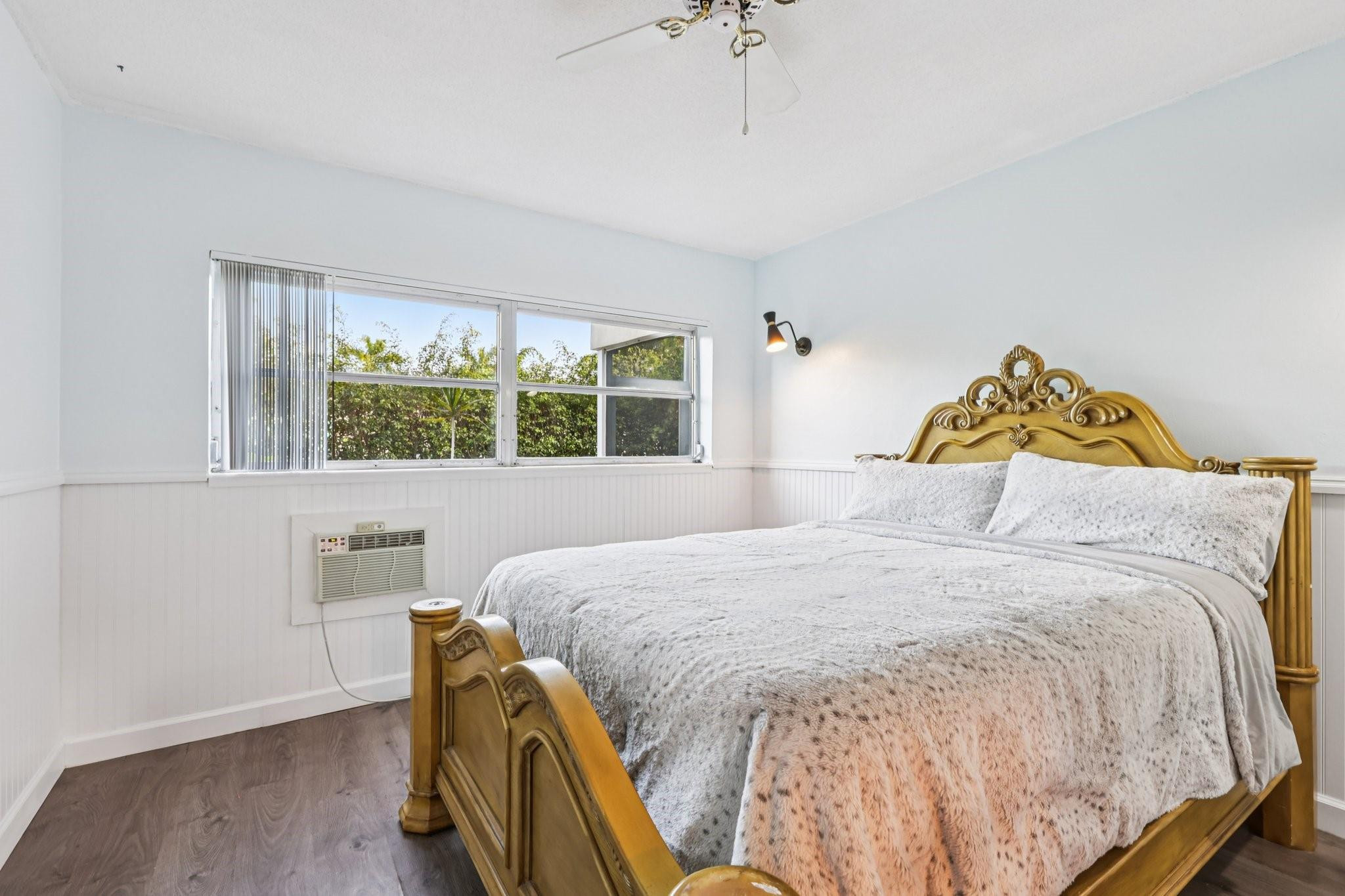 2131 Northeast 42nd Court, Unit 106E Lighthouse Point, FL 33064 - Photo 16 of 33 a bedroom with a bed and wooden floor