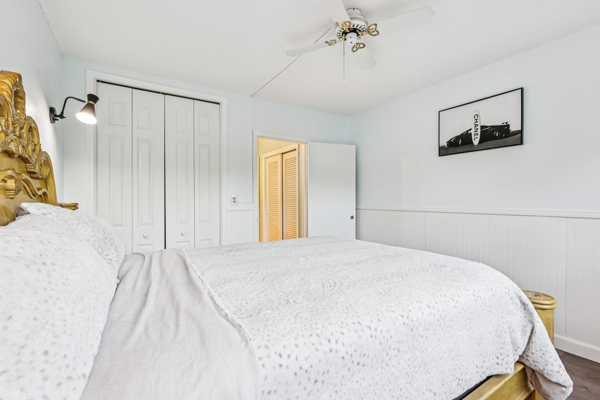 2131 Northeast 42nd Court, Unit 106E Lighthouse Point, FL 33064 - Photo 18 of 33 a bedroom with a bed and a chandelier