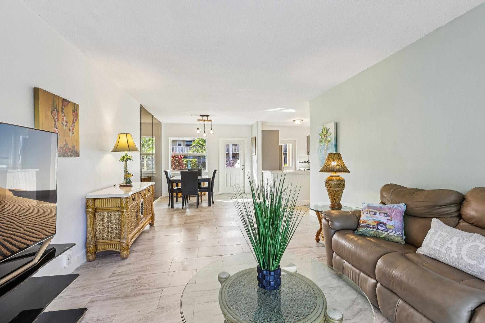 2131 Northeast 42nd Court, Unit 106E Lighthouse Point, FL 33064 - Photo 5 of 33 a living room with furniture potted plant and kitchen view