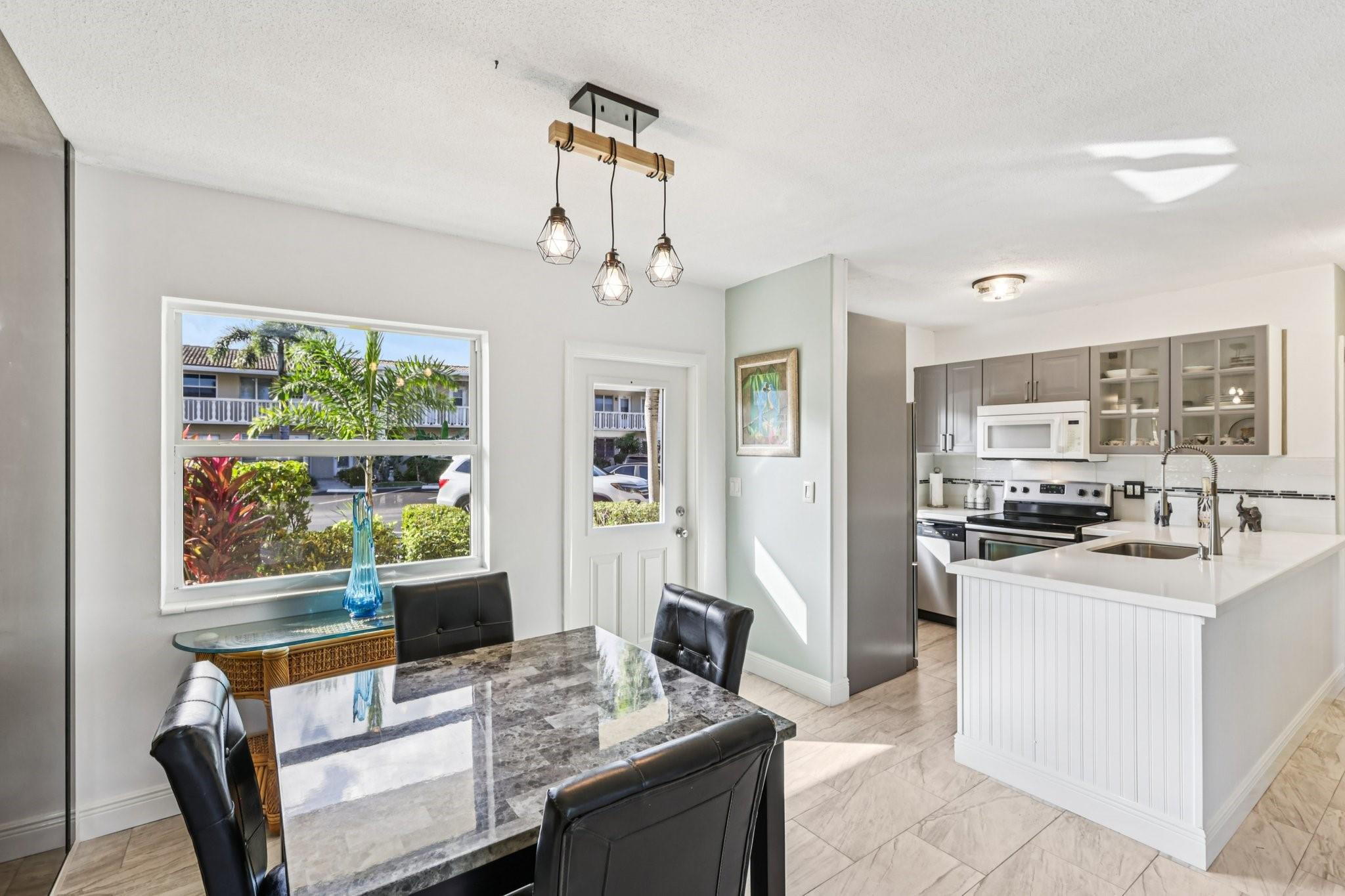 2131 Northeast 42nd Court, Unit 106E Lighthouse Point, FL 33064 - Photo 10 of 33 a view of a dining room with furniture window and outside view