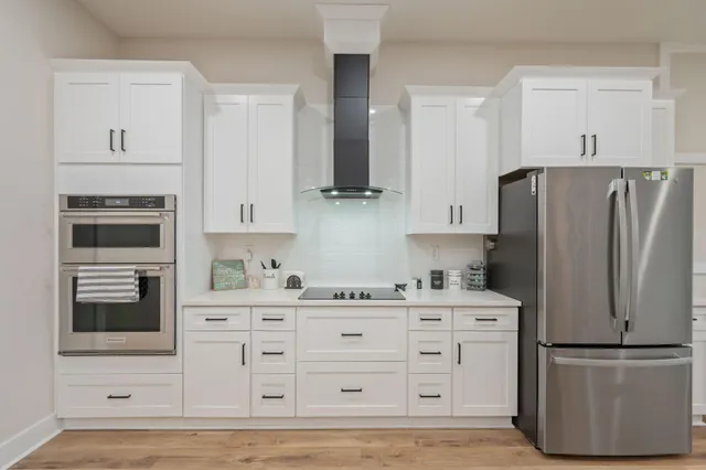 a kitchen with stainless steel appliances a refrigerator stove and cabinets