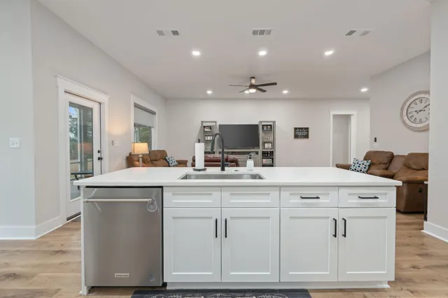 a kitchen with white cabinets and sink