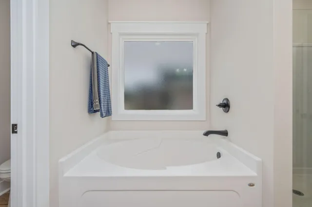 a white bath tub sitting next to a shower