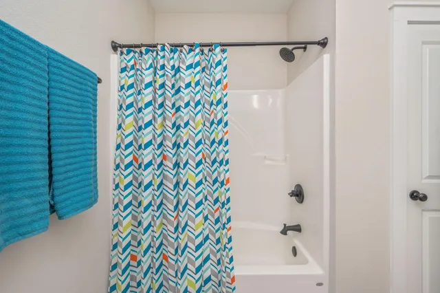 a bathroom with a shower curtain and a window