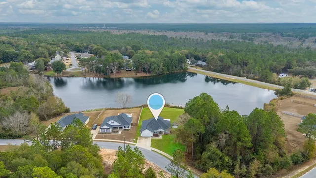 an aerial view of a house with outdoor space lake view and mountain view