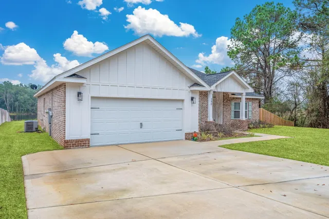 a view of a house with a yard and large tree