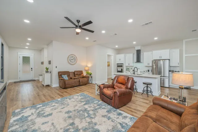 a living room with furniture and kitchen view