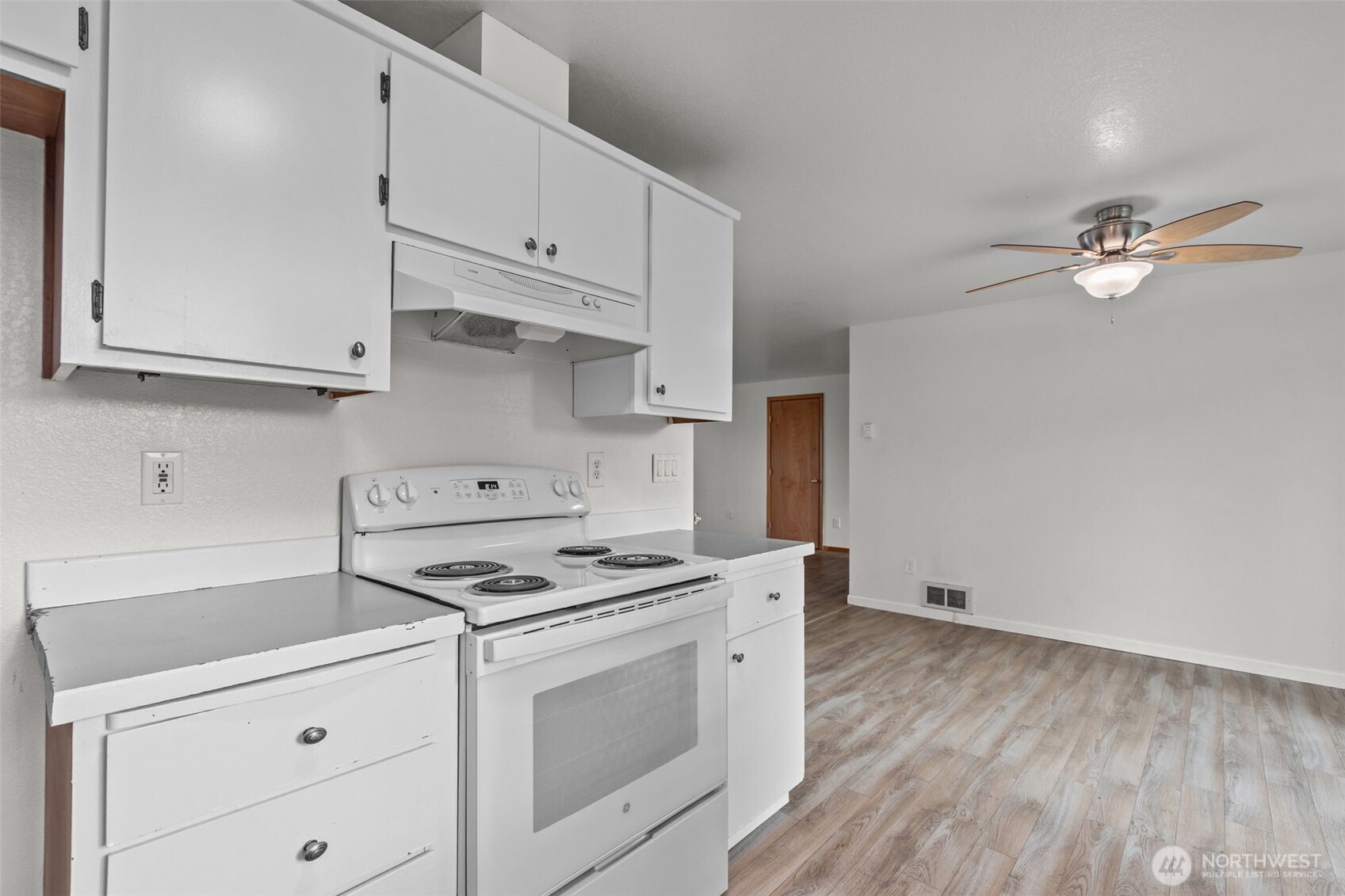 224 7th Street Gold Bar, WA 98251 - Photo 11 of 35 a kitchen with granite countertop a stove a sink and dishwasher with white cabinets