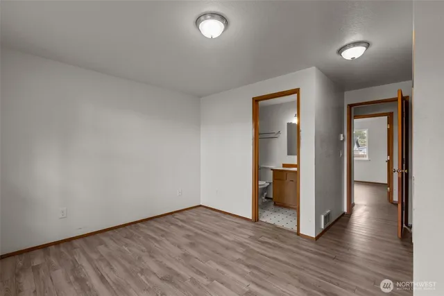 an empty room with wooden floor and closet