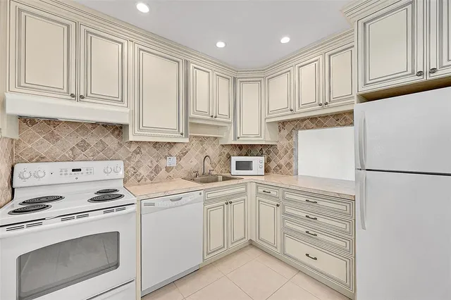 a kitchen with white cabinets and white appliances