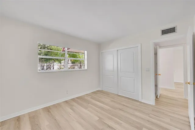 an empty room with wooden floor and a window